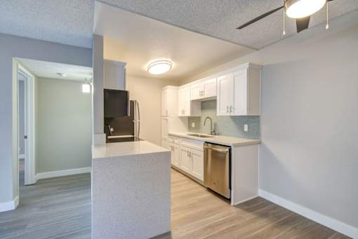 a renovated kitchen with white cabinets and stainless steel appliances at La Jolla Blue, San Diego