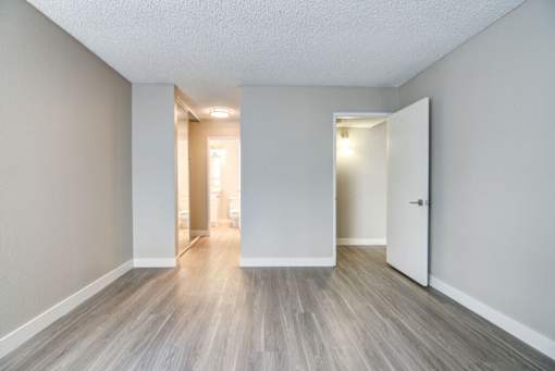 an empty living room with white walls and wood floors at La Jolla Blue, San Diego, CA 92122