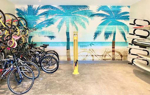 a group of bikes parked in front of a wall mural of a beach with palm at La Jolla Blue, San Diego, CA
