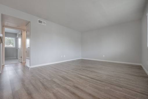 an empty living room with white walls and wood floors at Napa Green Apartments LLC, Napa California