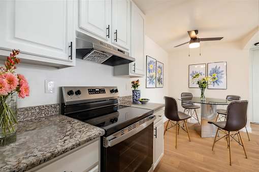 A kitchen with a black stove top oven and a marble counter top.at Summerhill Place Apartments, Union City, CA 94587