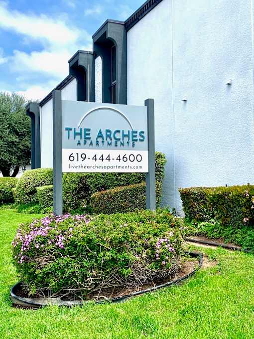 a sign for the arches in front of a building at The Arches Apartments, LLC, El Cajon California 
