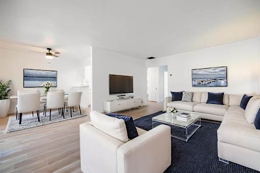 A modern living room with white furniture and a flat screen TV at Summerwood Apartment , Santa Clara