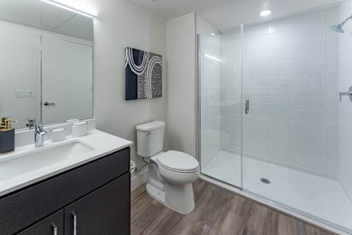 A bathroom with a toilet, sink, and shower.