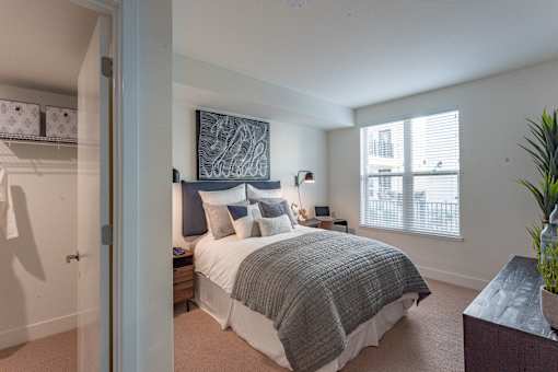 A bedroom with a large bed and a painting above it.