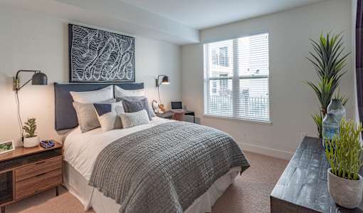 A bedroom with a large bed and a painting on the wall.