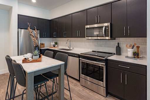 A kitchen with a table and chairs and a refrigerator.