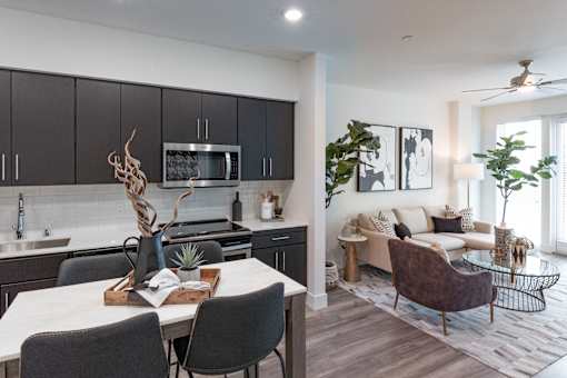 A modern kitchen with a dining table set for two.