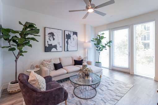 A living room with a couch, chair, and a ceiling fan.
