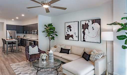 A living room with a white couch, a coffee table, and a ceiling fan.