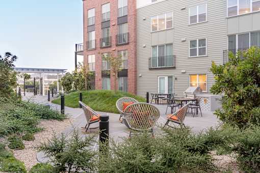 A modern apartment complex with a courtyard and seating area.