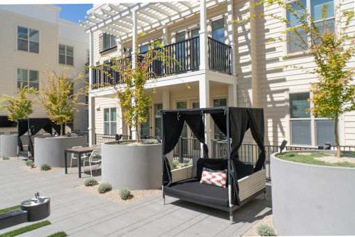 A patio with a black and white striped couch and a table.