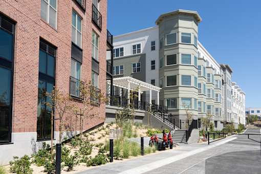 A row of modern buildings with a clear blue sky above them.
