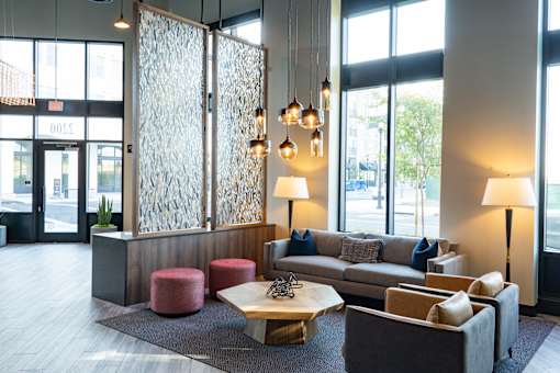 A modern waiting room with a glass partition and comfortable seating.