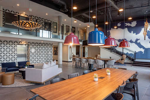 A modern dining area with a long wooden table and chairs.