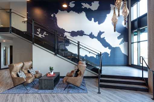 A living room with a staircase and a wall mural.