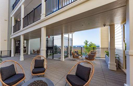 A balcony with a table and chairs overlooking the ocean.