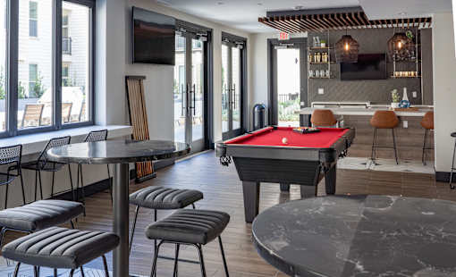 A room with a pool table and a television.