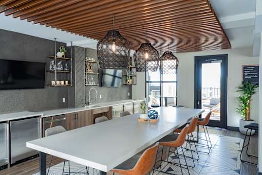 A modern kitchen with a long table and chairs.