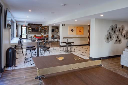 A ping pong table is in the middle of a room with a lot of furniture.