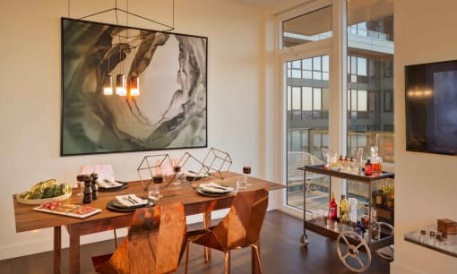 a dining room with a table and chairs and a painting on the wall at SKY Apartments, New York