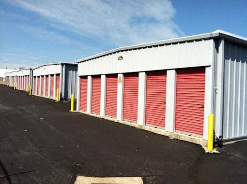 A storage facility with red doors and a yellow post.