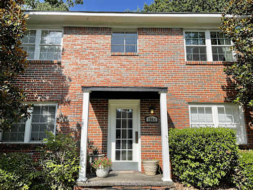 the front of a brick house with a white door