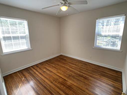 a living room with wood floors and a ceiling fan