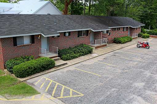 an aerial view of a brick house with a motor scooter parked in the driveway