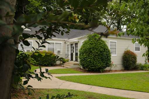 a white house with a sidewalk in front of it