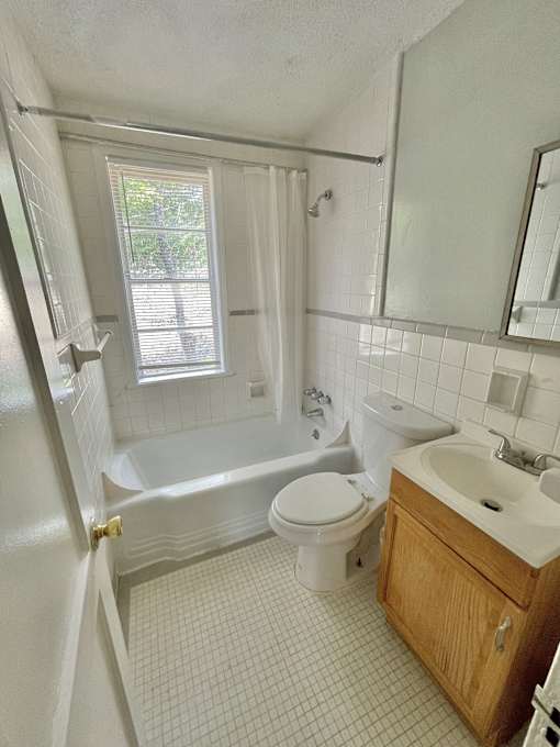 a bathroom with a toilet and a tub and a sink