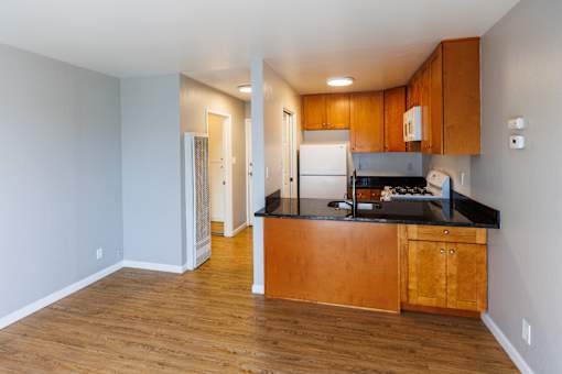 A kitchen with wooden cabinets and a black countertop.
