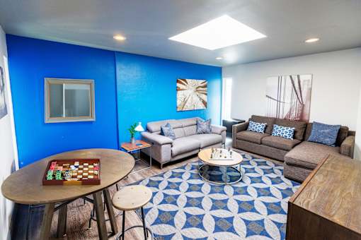 A blue wall with a chess board on a table.
