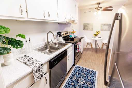 A kitchen with a sink, stove, and refrigerator.