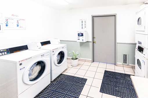 A laundry room with washing machines and a door.