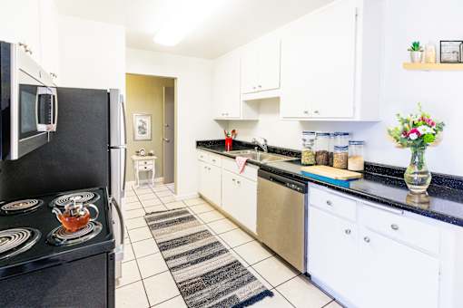 A kitchen with black countertops and white cabinets.