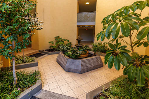 A small garden with a fountain in the middle.