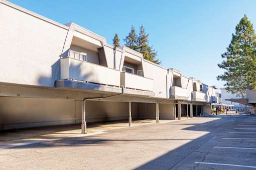 A long row of white buildings with a clear blue sky above.
