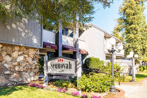 The Sequoah Apartments sign is in front of a stone building.