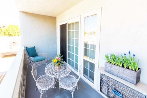 A balcony with a table and chairs.