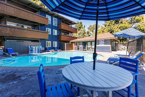 A blue and white pool area with a table and chairs.