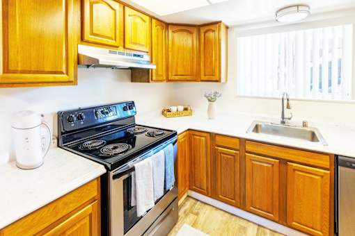 A kitchen with wooden cabinets and a black stove top oven.