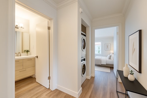 A hallway with a washing machine in the doorway.