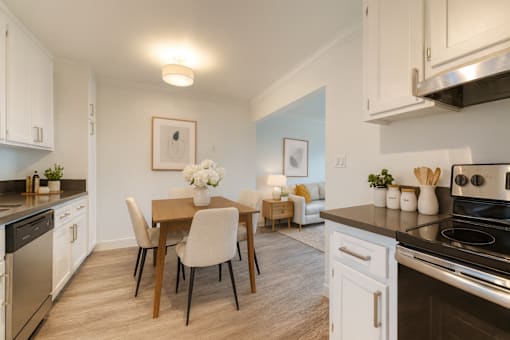 A kitchen with a dining table and chairs.