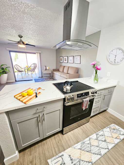 A modern kitchen with a large island and a stove top oven.