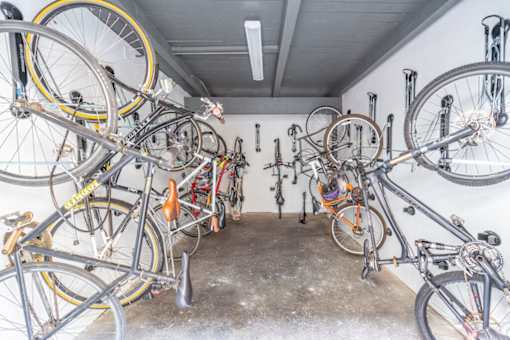A room full of bicycles hanging on the wall.