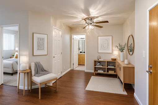 A living room with a chair, a table, and a ceiling fan.