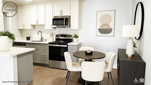 A modern kitchen with white cabinets and a black stove top oven.