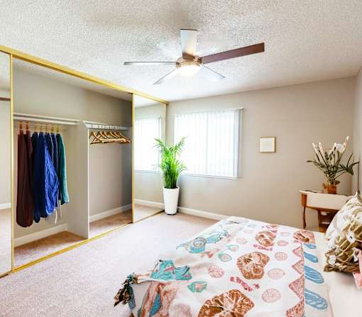 a bedroom with a bed and a ceiling fan