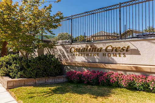 A sign that says "Carmelita Crest Apartment Homes" is on a wall.